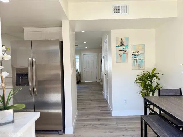 a view of a hallway with wooden floor and a potted plant