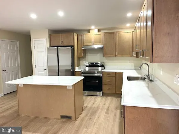 a kitchen with a sink a stove a refrigerator and a oven