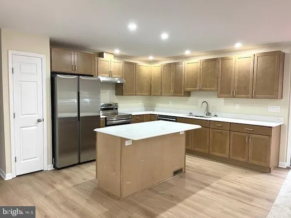 a kitchen with kitchen island a sink stainless steel appliances and cabinets