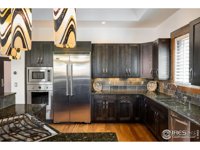 a kitchen with stainless steel appliances granite countertop a refrigerator and a sink