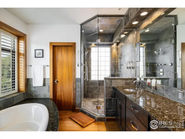 a bathroom with a granite countertop sink a bathtub and shower