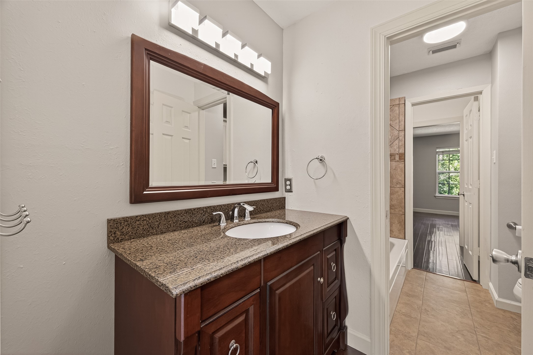 6131 Hampton Way Court Spring, TX 77389 - Photo 27 of 50 a bathroom with a granite countertop sink a mirror and a vanity