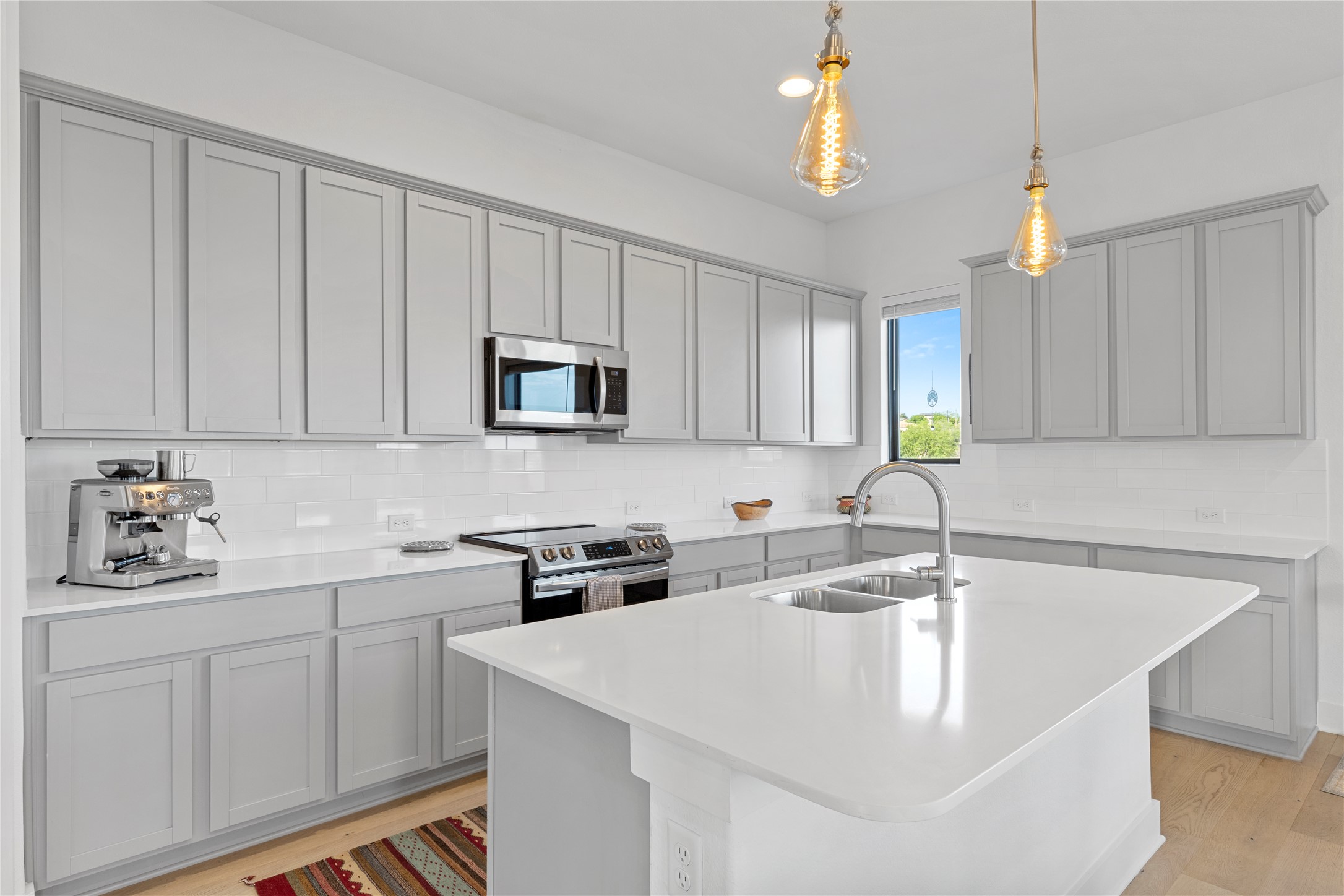 2050 Lohmans Spur Road, Unit 1302 Lakeway, TX 78734 - Photo 3 of 18 a kitchen with stainless steel appliances granite countertop a sink a stove and dishwasher with white cabinets