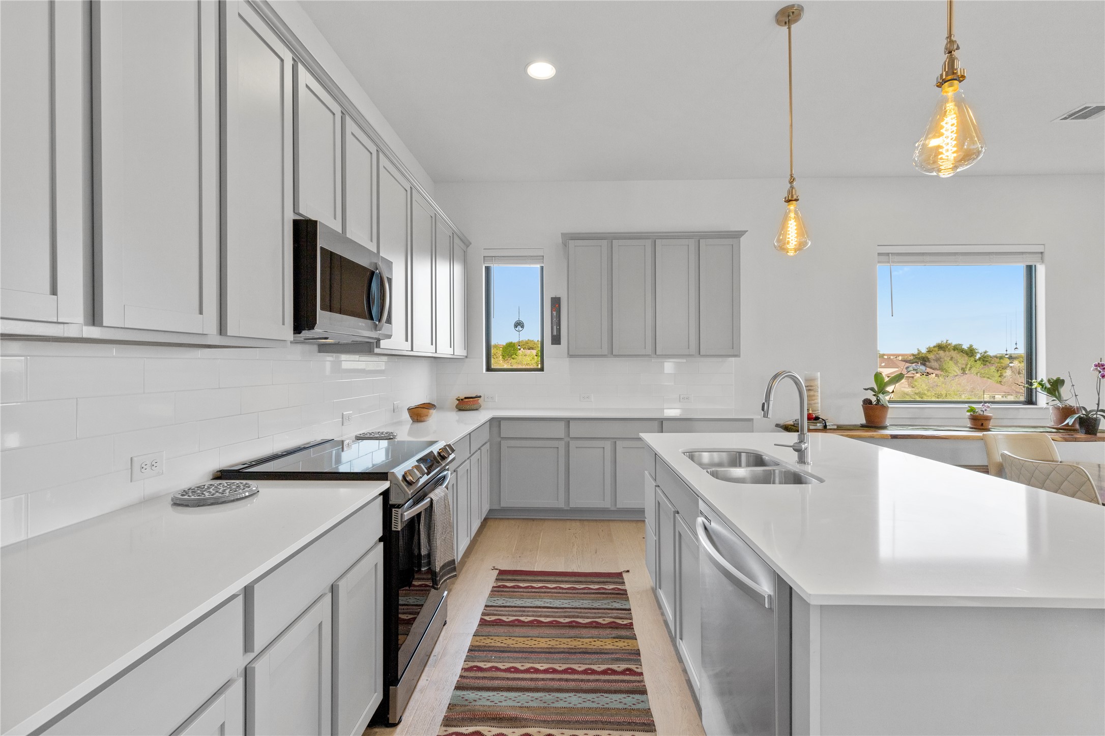2050 Lohmans Spur Road, Unit 1302 Lakeway, TX 78734 - Photo 7 of 18 a kitchen with a sink stove top oven and cabinets