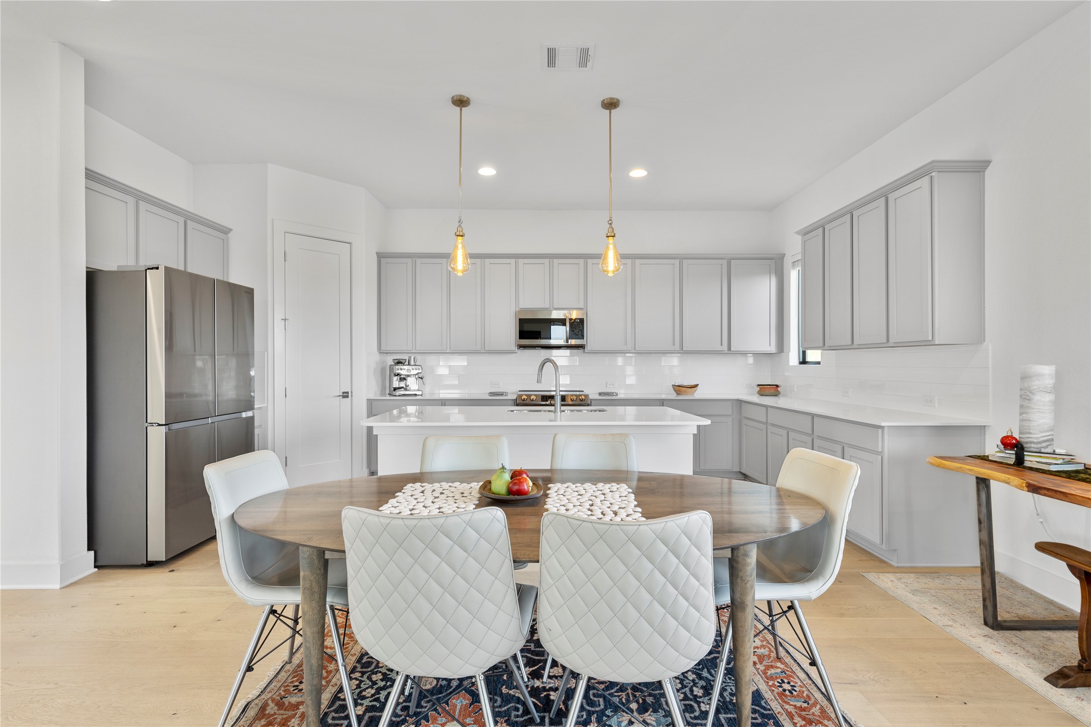 2050 Lohmans Spur Road, Unit 1302 Lakeway, TX 78734 - Photo 8 of 18 a kitchen with a dining table chairs refrigerator and cabinets