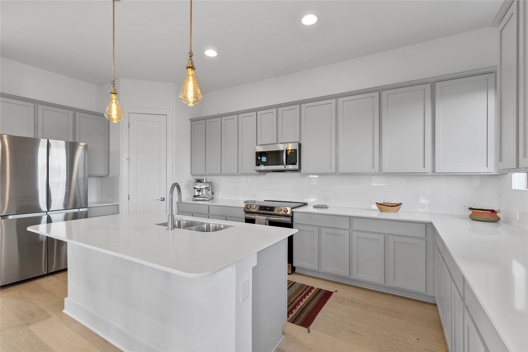 2050 Lohmans Spur Road, Unit 1302 Lakeway, TX 78734 - Photo 9 of 18 a kitchen with stainless steel appliances granite countertop a sink a stove a refrigerator a center island with wooden floor
