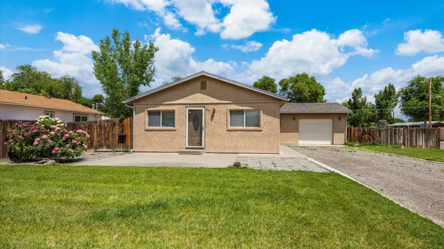 a front view of a house with a garden and trees