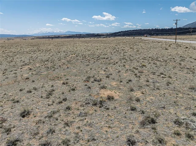 a view of an empty room with wooden floor and fence