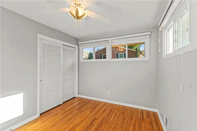 a view of empty room with a window and wooden floor