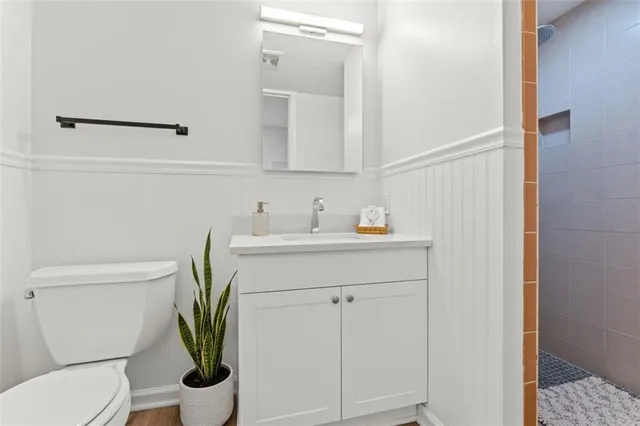 a bathroom with a sink a toilet and mirror