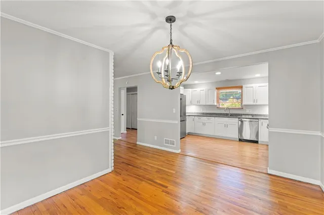 a view of a kitchen with wooden floor and a sink