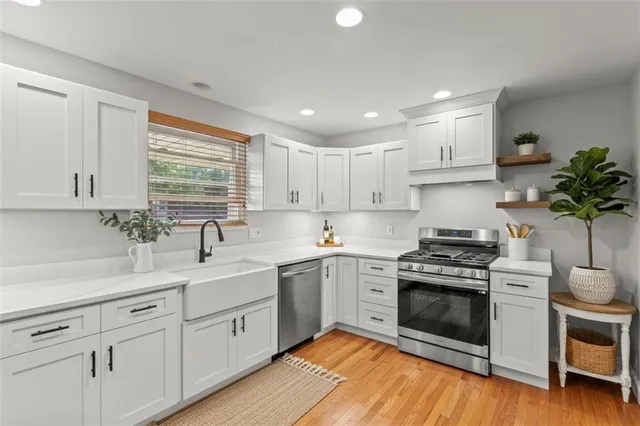a kitchen with stainless steel appliances a stove sink and cabinets