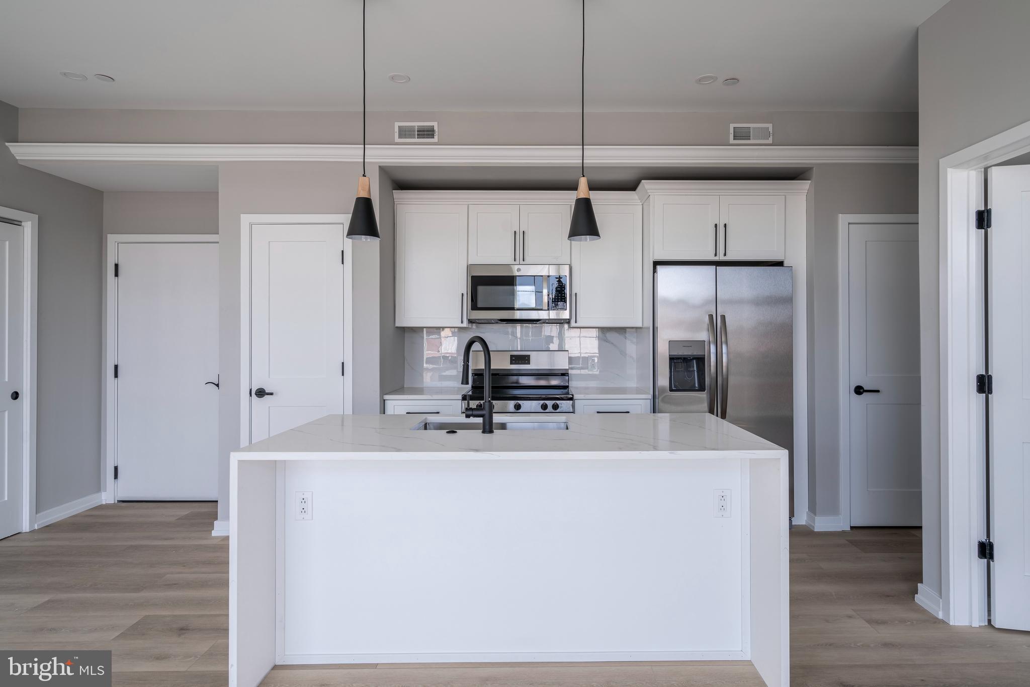 2401 Washington Avenue, Unit 3D Philadelphia, PA 19146 - Photo 1 of 18 a kitchen with kitchen island a sink stainless steel appliances and refrigerator