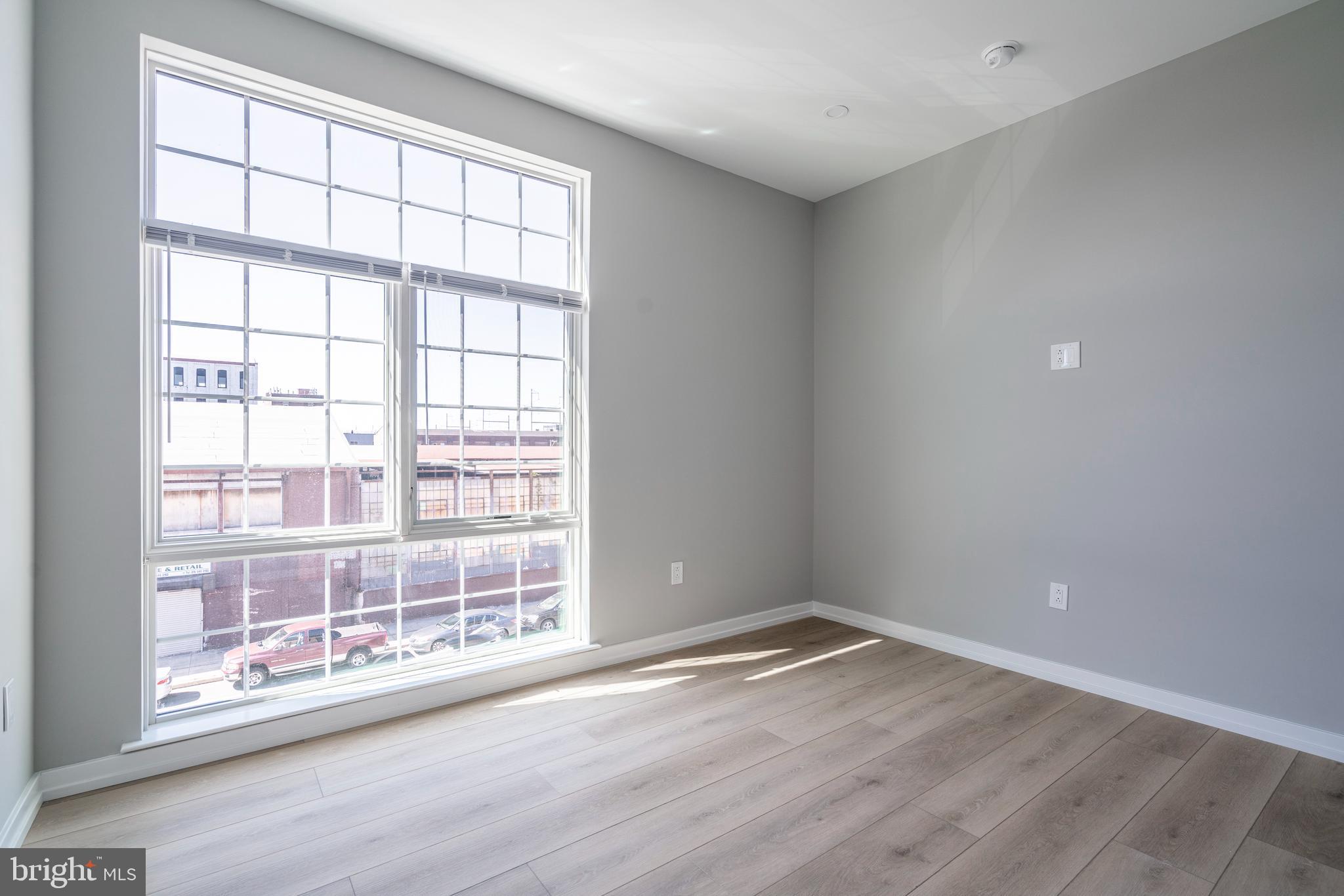 2401 Washington Avenue, Unit 3D Philadelphia, PA 19146 - Photo 12 of 18 an empty room with wooden floor and windows