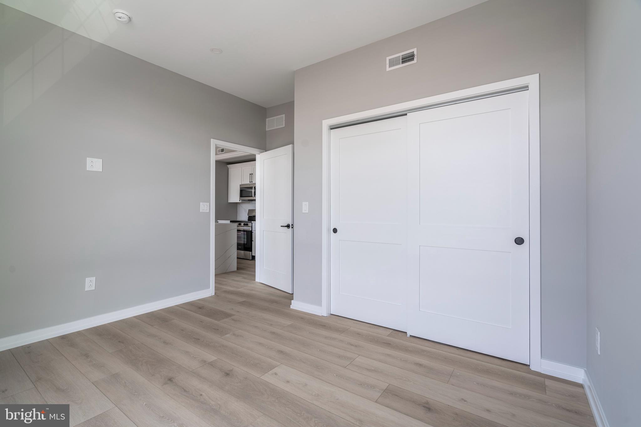 2401 Washington Avenue, Unit 3D Philadelphia, PA 19146 - Photo 13 of 18 a view of an empty room with wooden floor and closet