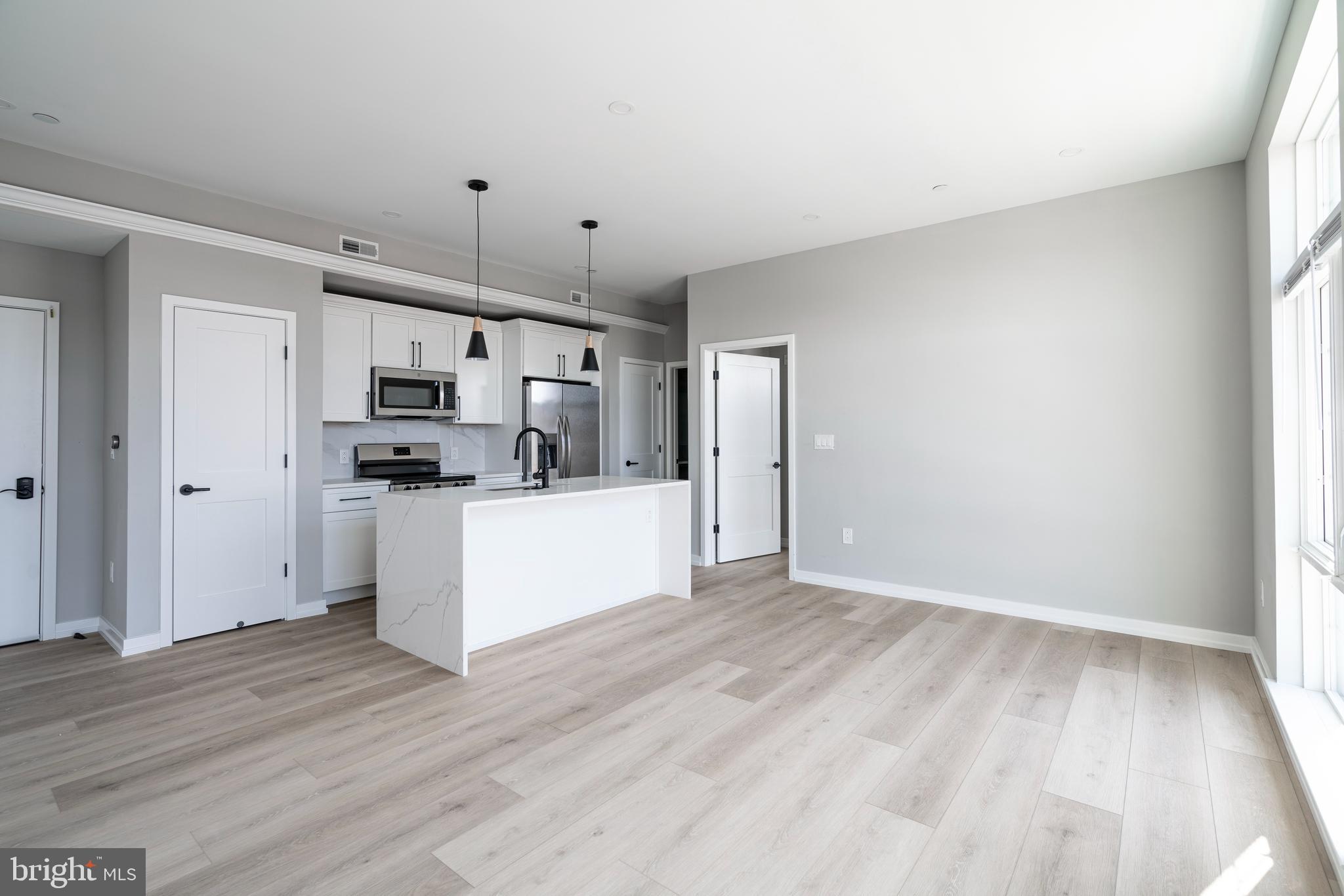 2401 Washington Avenue, Unit 3D Philadelphia, PA 19146 - Photo 3 of 18 a view of kitchen with refrigerator cabinets and wooden floor