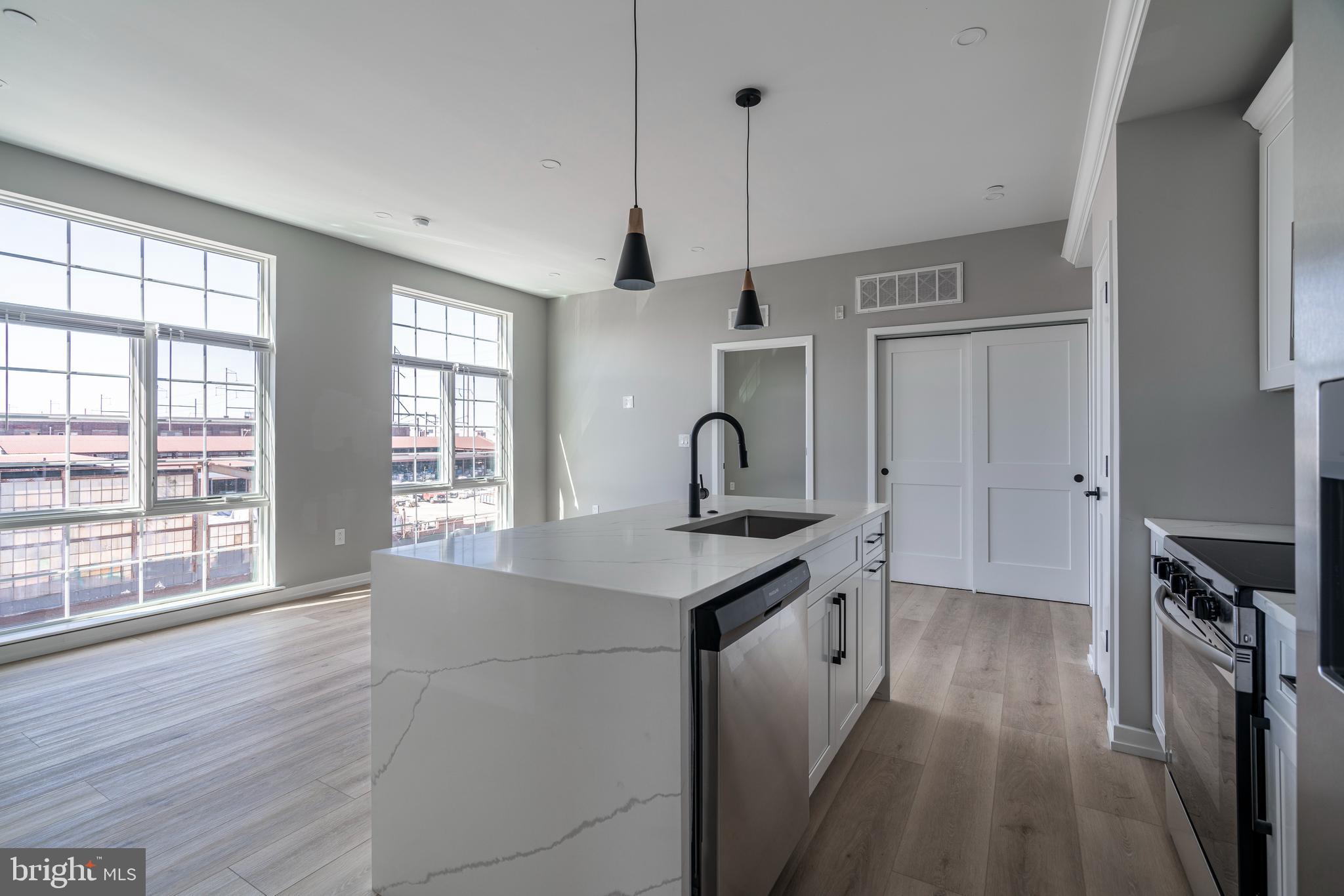 2401 Washington Avenue, Unit 3D Philadelphia, PA 19146 - Photo 7 of 18 a kitchen with stainless steel appliances granite countertop a sink a stove and a wooden floors