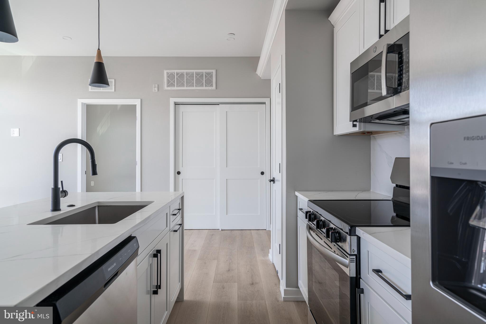 2401 Washington Avenue, Unit 3D Philadelphia, PA 19146 - Photo 8 of 18 a kitchen with stainless steel appliances granite countertop a sink stove and refrigerator
