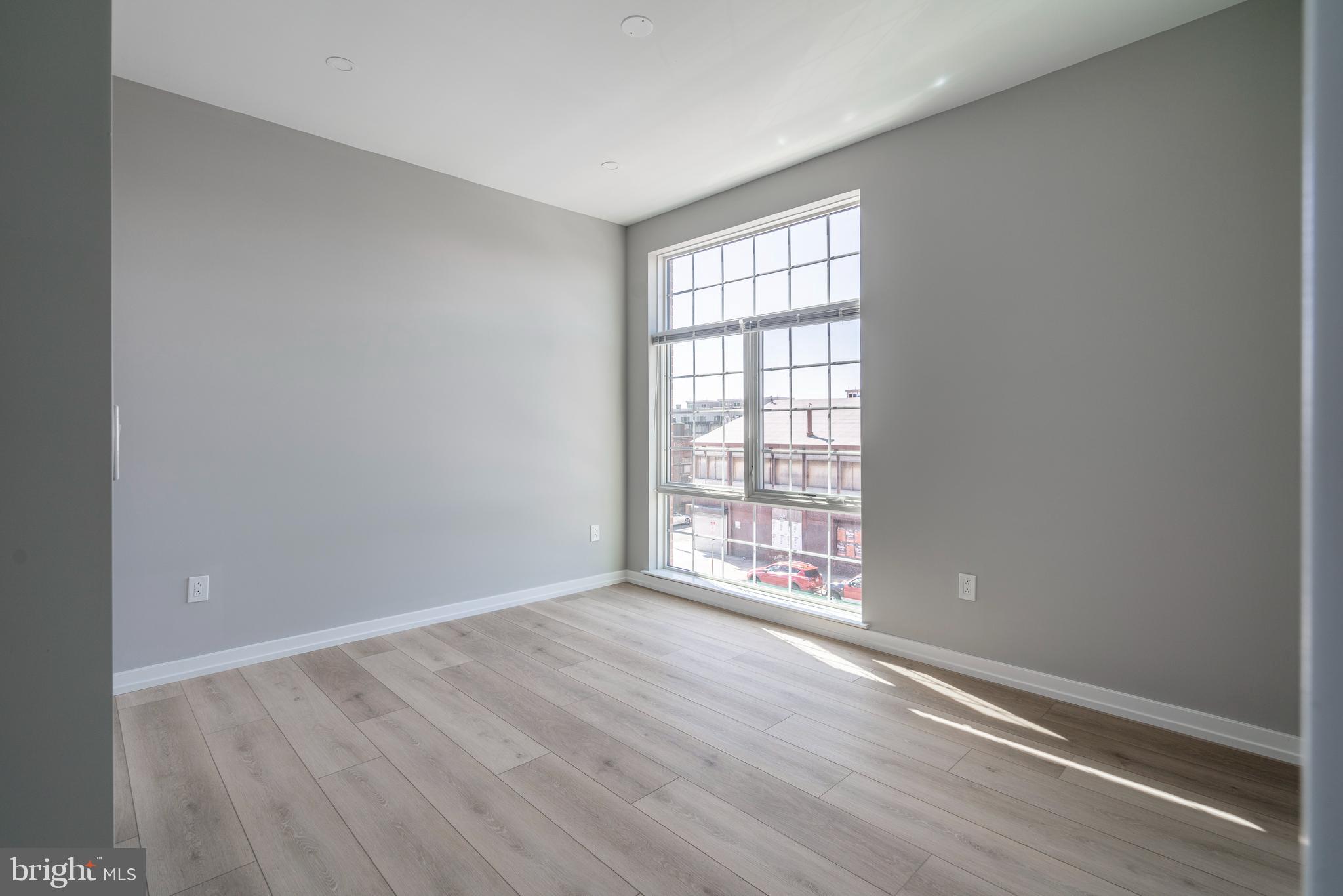 2401 Washington Avenue, Unit 3D Philadelphia, PA 19146 - Photo 10 of 18 an empty room with wooden floor and windows