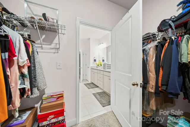 a view of walk in closet with clothes and shoes