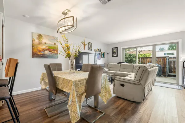 a living room with furniture a large window and wooden floor