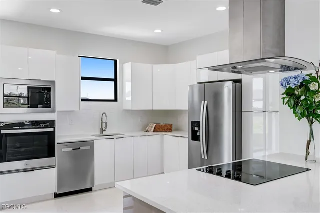 a kitchen with stainless steel appliances a sink stove and refrigerator