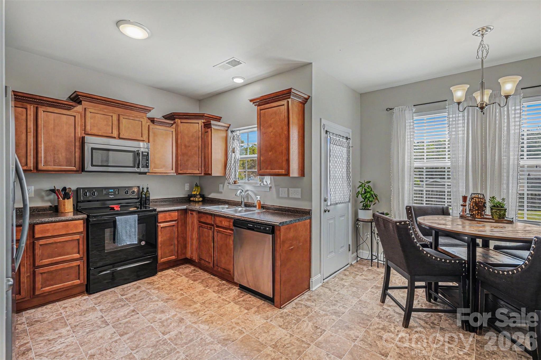 1610 Walter Hasty Road Monroe, NC 28110 - Photo 10 of 32 a kitchen with stainless steel appliances granite countertop a stove a sink dishwasher a microwave oven and a dining table with wooden cabinet