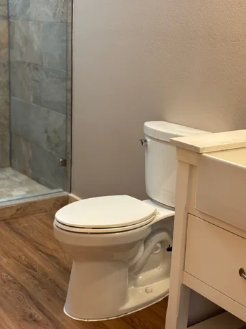 a white toilet sitting next to a bath tub