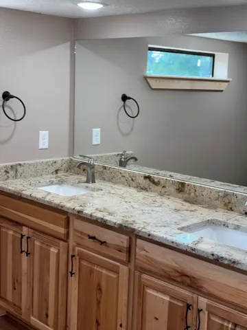 a bathroom with a granite countertop sink and a mirror