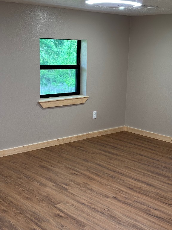207 George Wilson Road Huntsville, TX 77320 - Photo 22 of 26 a view of an empty room with wooden floor and a window