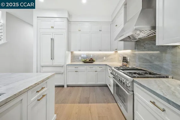 a kitchen with white cabinets and appliances