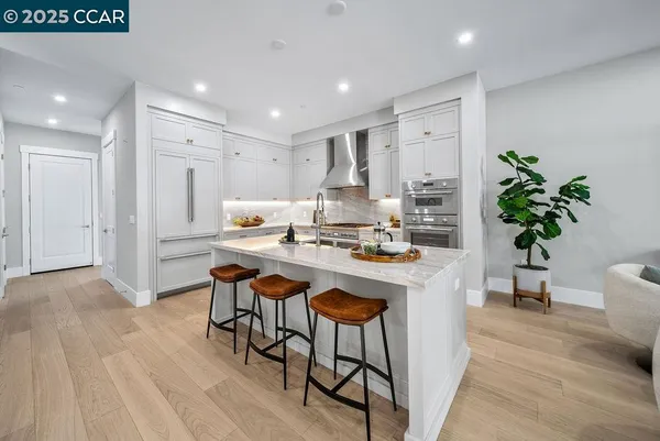 a room with stainless steel appliances kitchen island a table and chairs in it