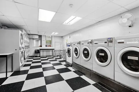 a view of a storage & utility room with stainless steel appliances wooden floor