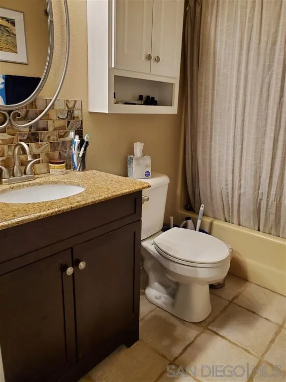 4876 Sumac Place Oceanside, CA 92057 - Photo 12 of 14 a bathroom with a granite countertop toilet sink and mirror