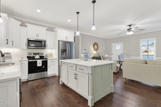 a large kitchen with cabinets wooden floor and stainless steel appliances