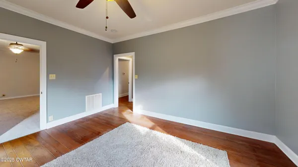 a view of a bedroom with wooden floor and cabinet