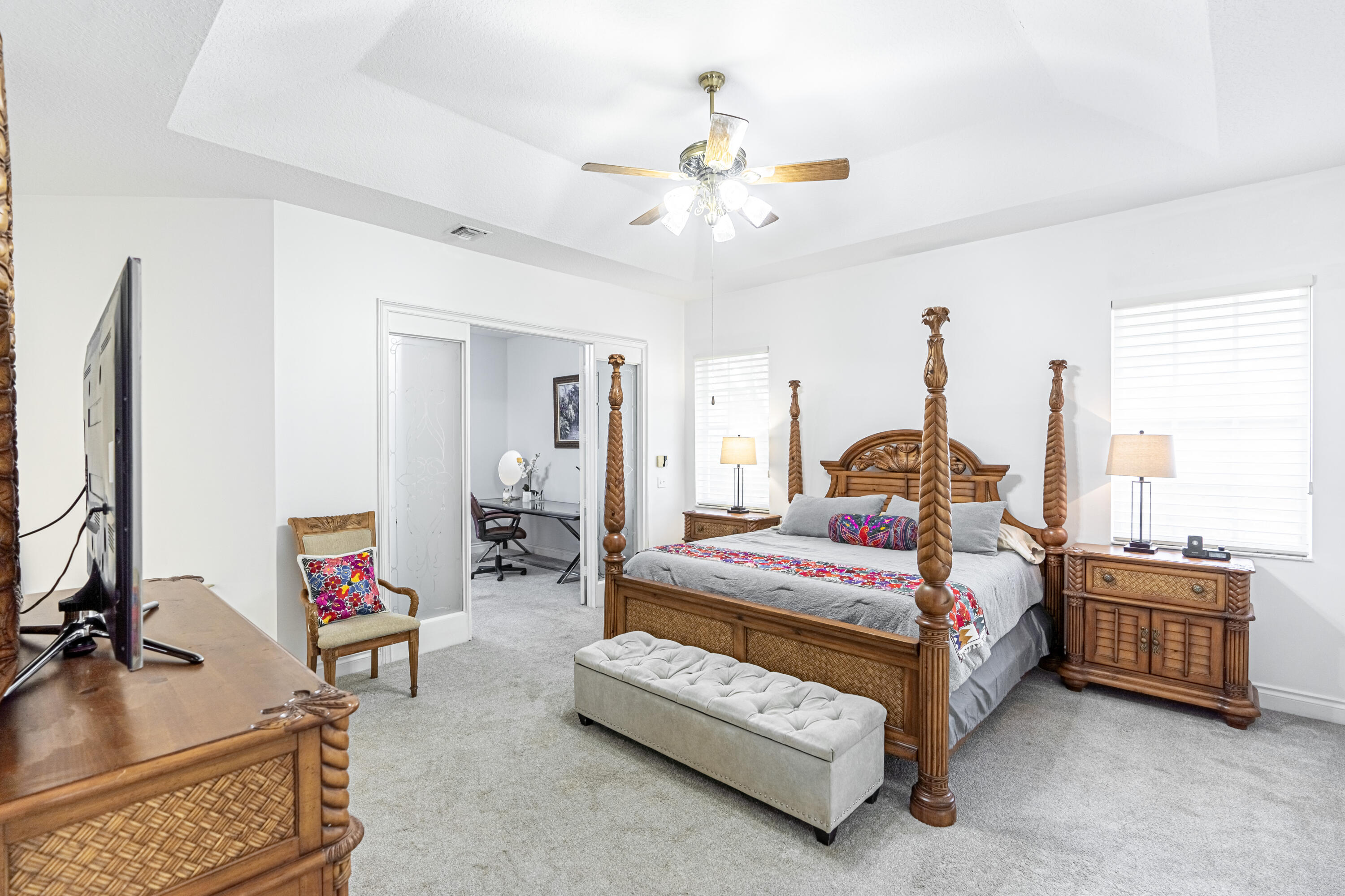 15350 Take Off Place Wellington, FL 33414 - Photo 17 of 44 a bedroom with a bed a chandelier and a couch