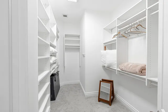 a view of walk in closet with clothes and shoes