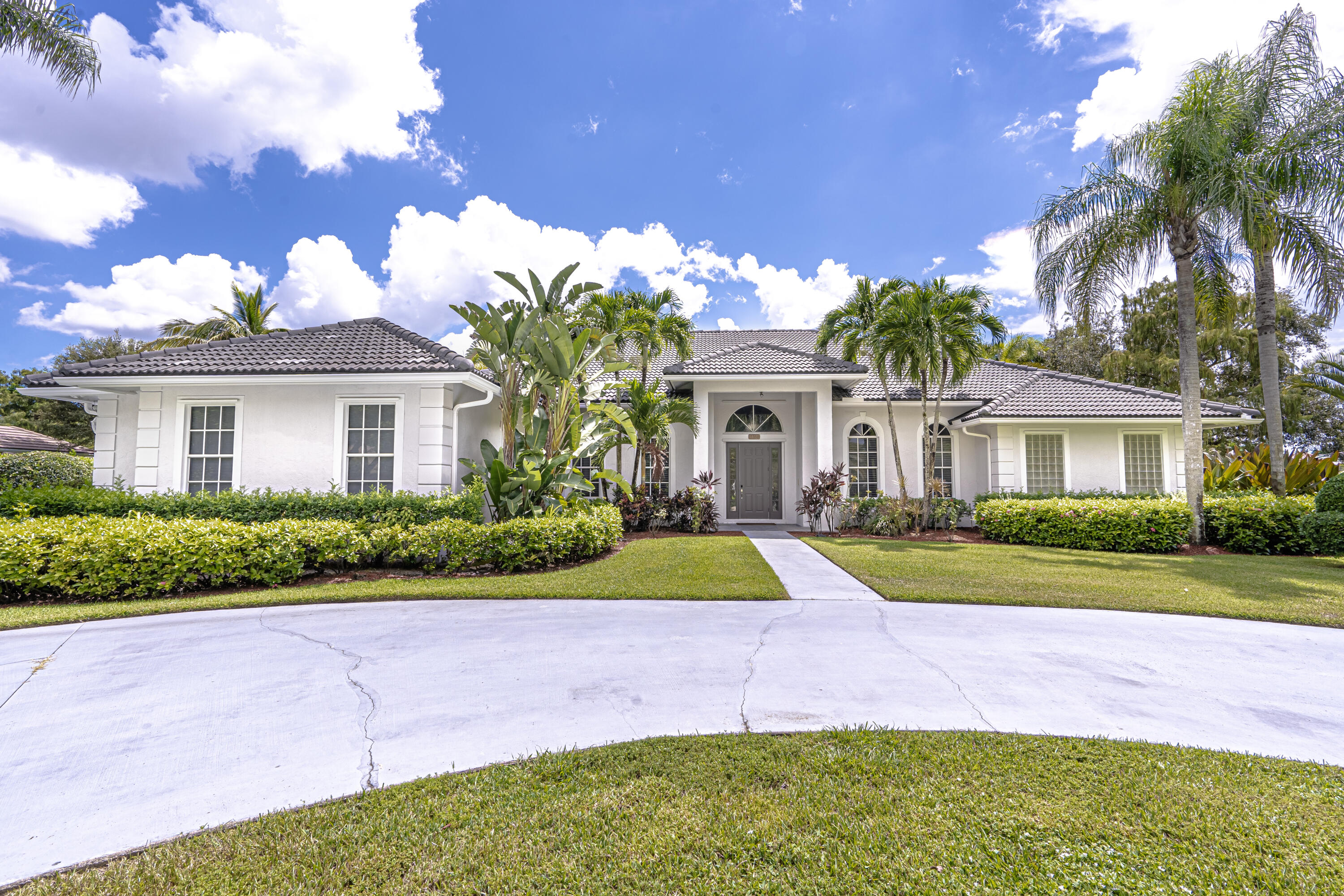 15350 Take Off Place Wellington, FL 33414 - Photo 2 of 44 a front view of a house with a yard