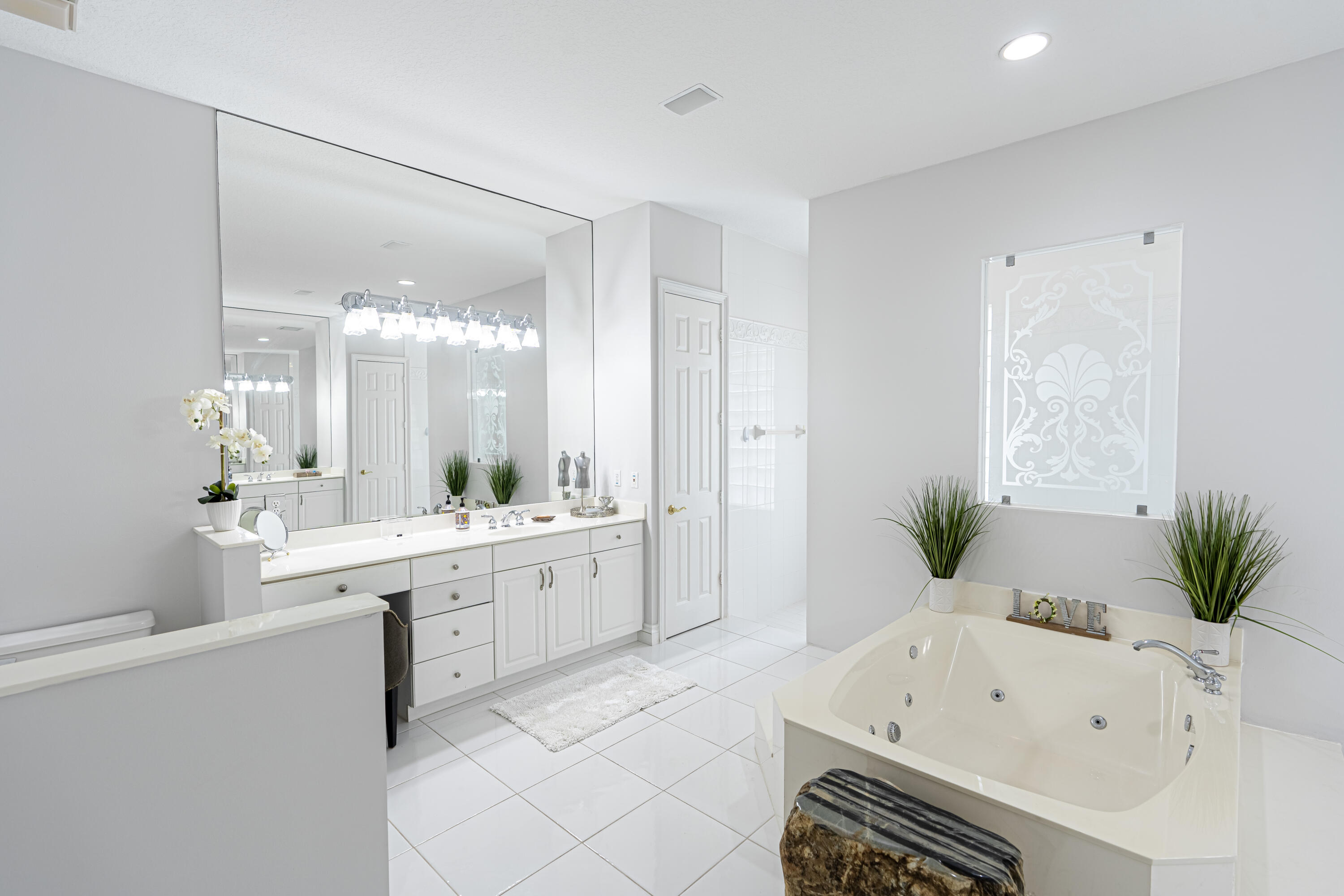 15350 Take Off Place Wellington, FL 33414 - Photo 22 of 44 a large white bathroom with a bathtub sink and mirror