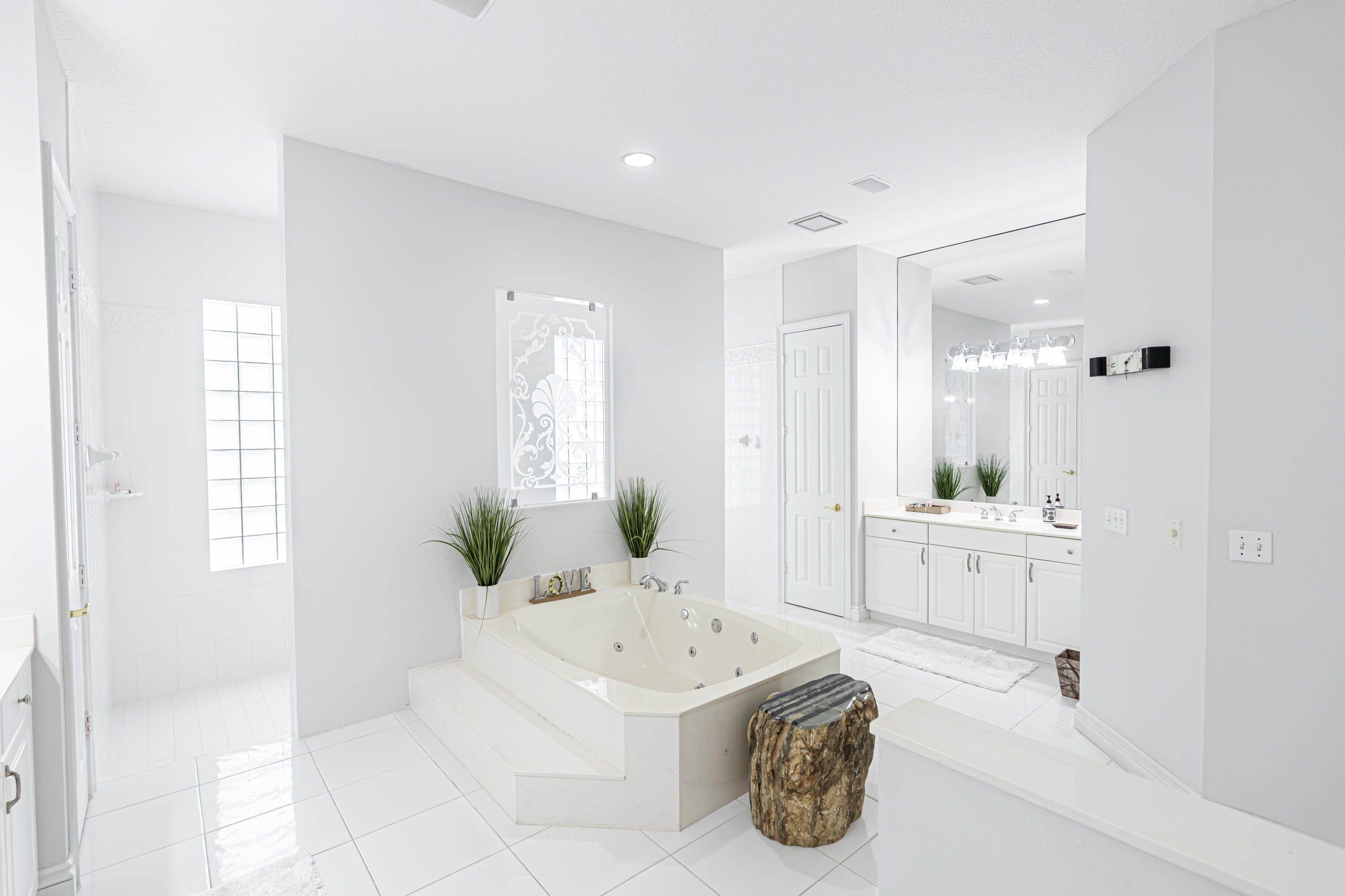 15350 Take Off Place Wellington, FL 33414 - Photo 25 of 44 a spacious bathroom with a double vanity sink a mirror and a bathtub