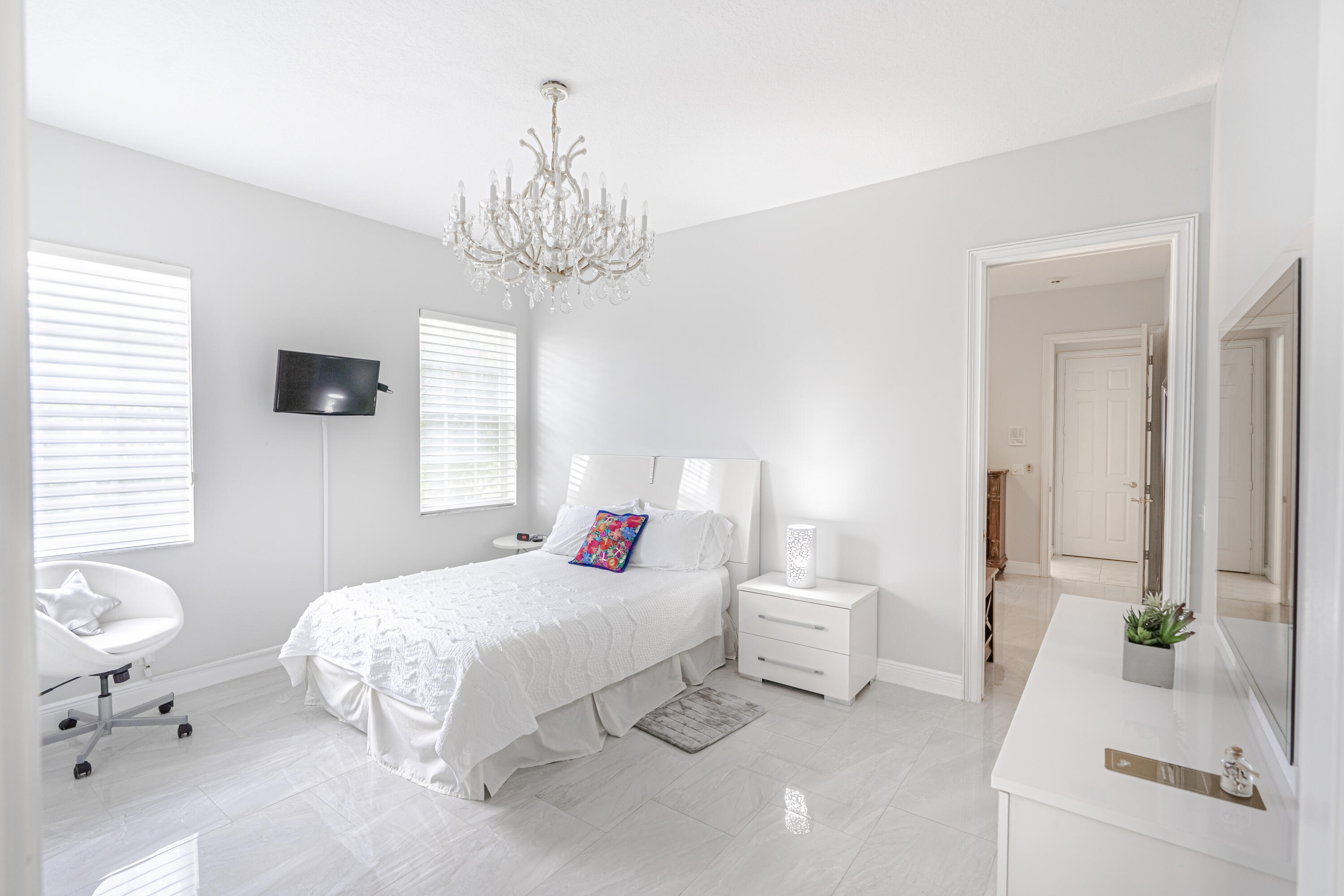 15350 Take Off Place Wellington, FL 33414 - Photo 27 of 44 a bedroom with a bed and a chandelier