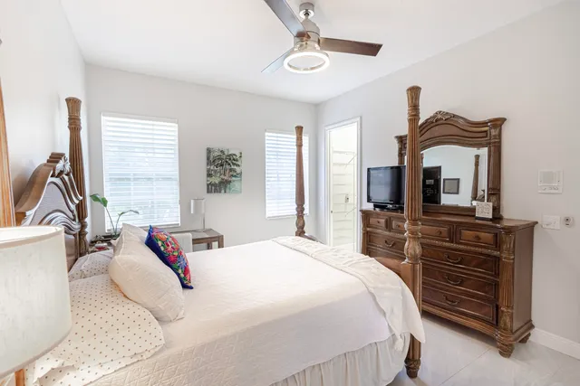 a bedroom with a bed a dresser and flat screen tv