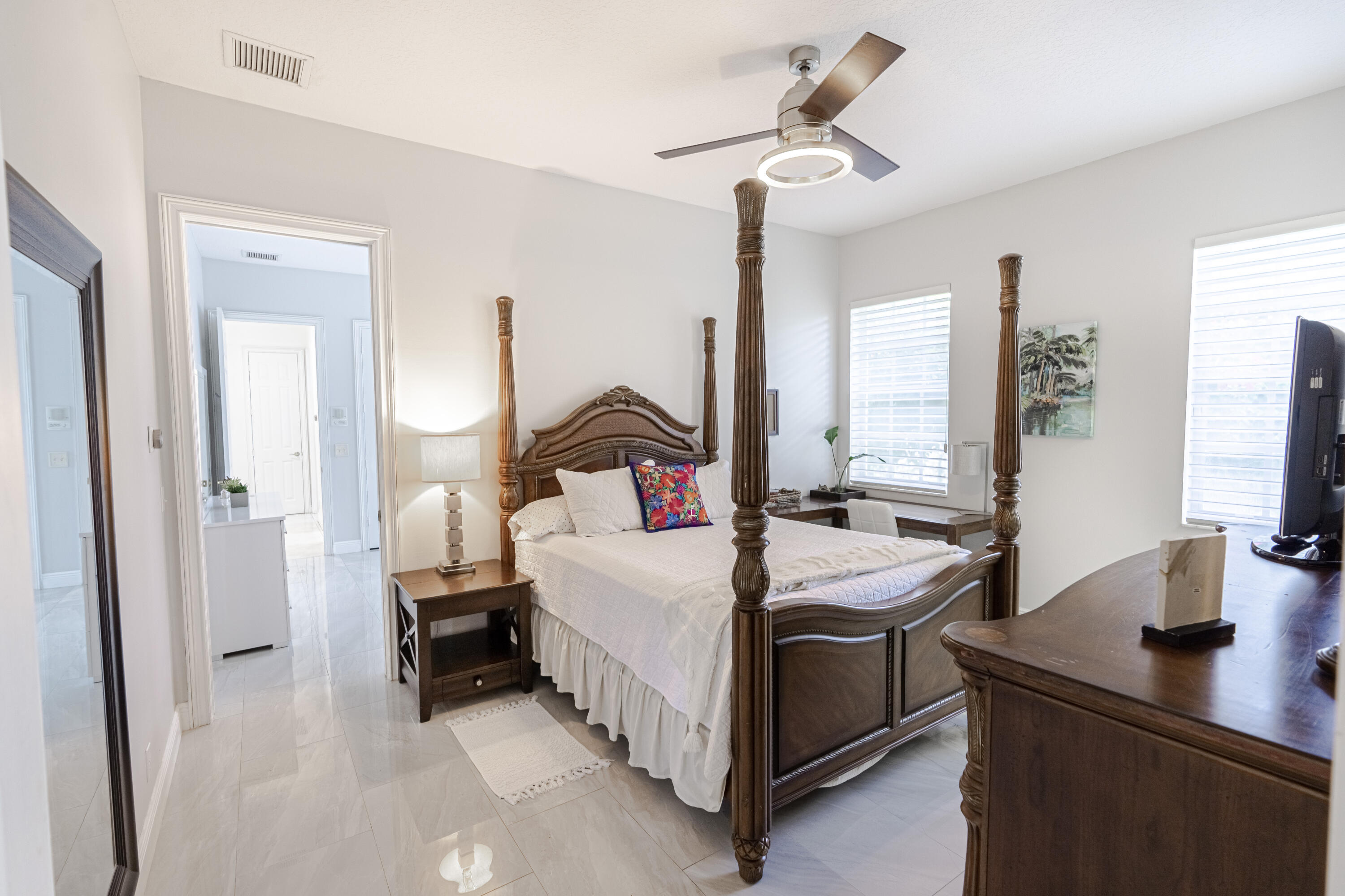 15350 Take Off Place Wellington, FL 33414 - Photo 30 of 44 a bedroom with a bed and a chandelier