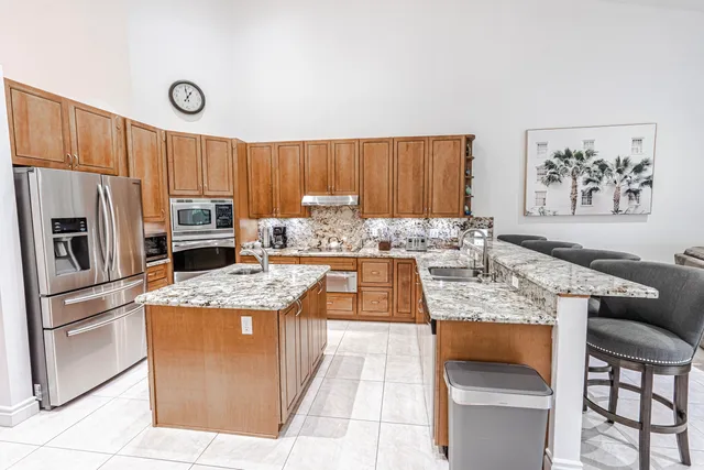 a kitchen with granite countertop a sink stove and refrigerator