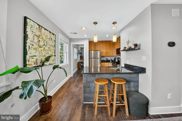 a kitchen with granite countertop white cabinets and stainless steel appliances