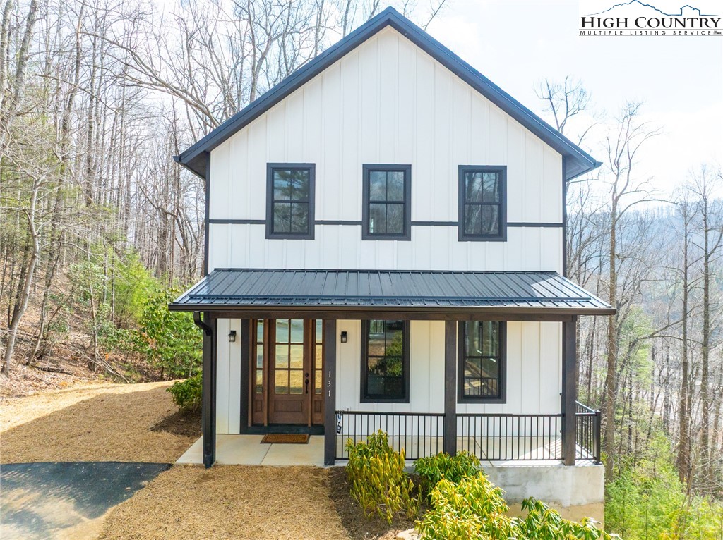 131 Bryce Way Boone, NC 28607 - Photo 27 of 38 a view of a white house with large windows and a small yard