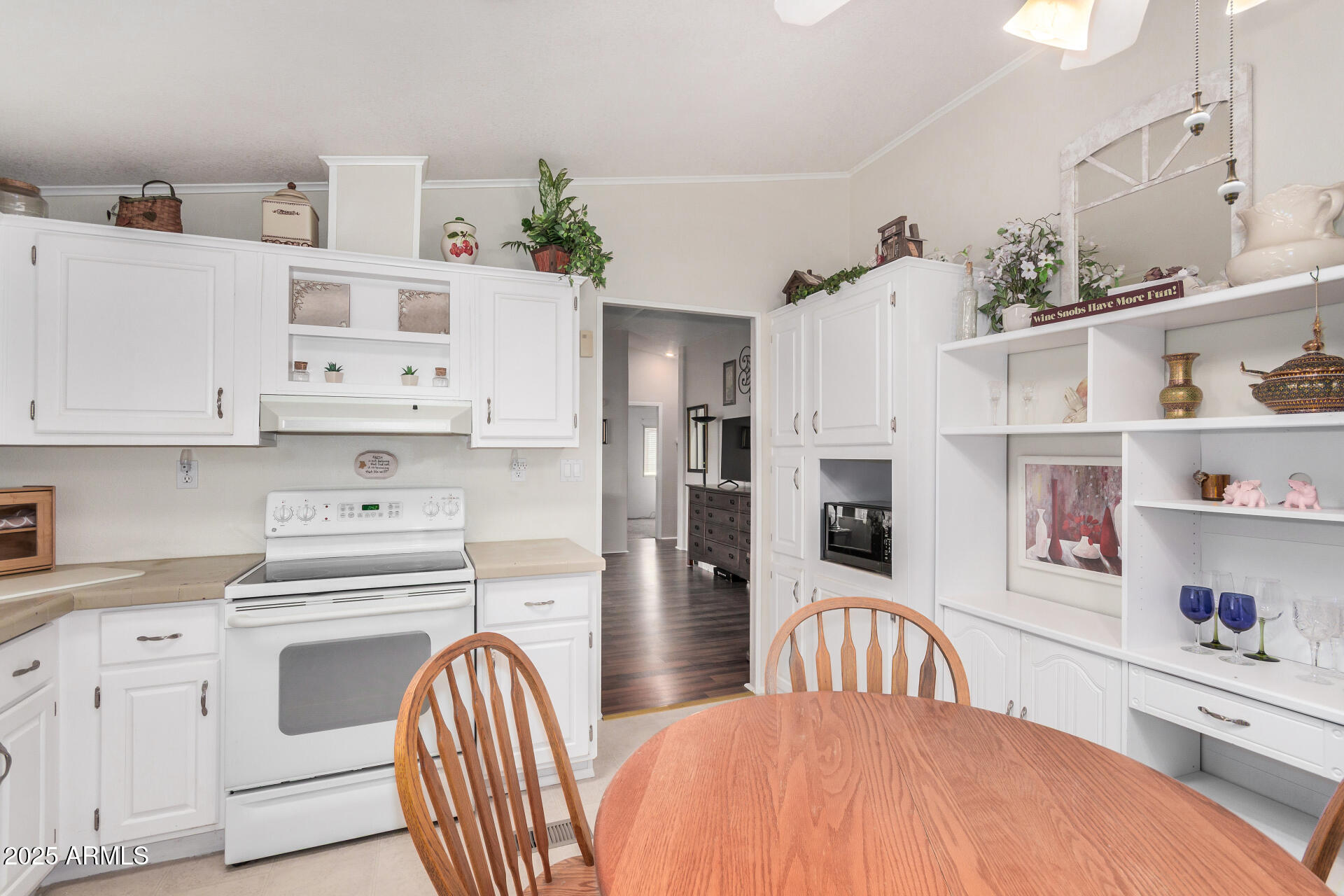 2208 West Baseline Avenue, Unit 114 Apache Junction, AZ 85120 - Photo 13 of 28 a kitchen with stainless steel appliances a refrigerator a stove a sink and white cabinets with wooden floor