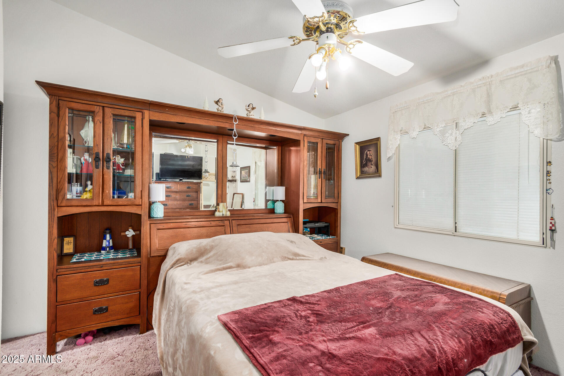 2208 West Baseline Avenue, Unit 114 Apache Junction, AZ 85120 - Photo 19 of 28 a spacious bedroom with a large bed and a chandelier