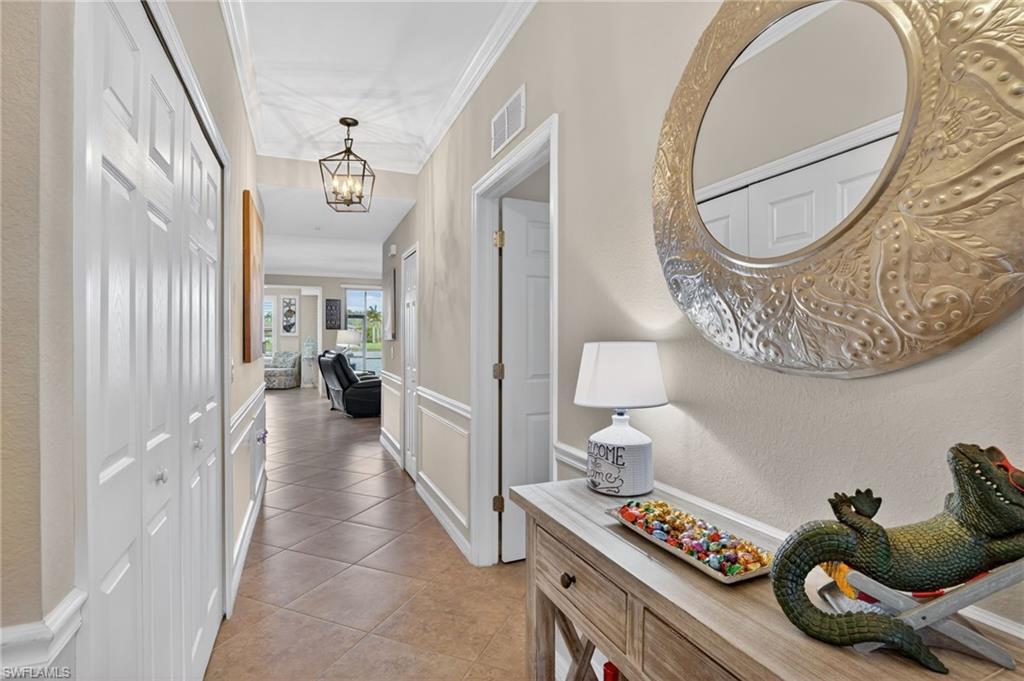 9513 Avellino Way, Unit 2014 Naples, FL 34113 - Photo 11 of 41 a hallway with furniture and a chandelier